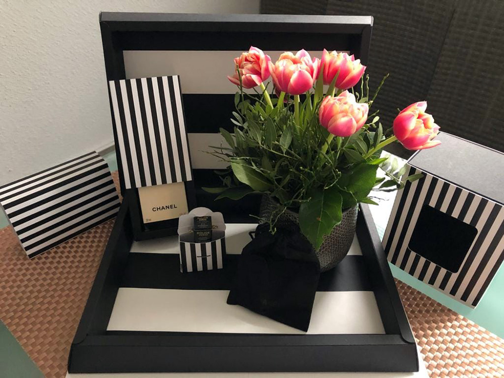 Individuelle Präsentverpackungen und Geschenkverpackungen mit Streifendesign Präsentverpackungen und Geschenkboxen mit schwarz-weißem Streifendesign neben Blumen und Dekoartikeln
